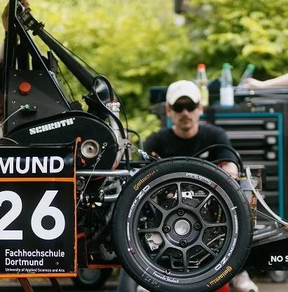 Teammitglied arbeitet am Rad des Rennwagens